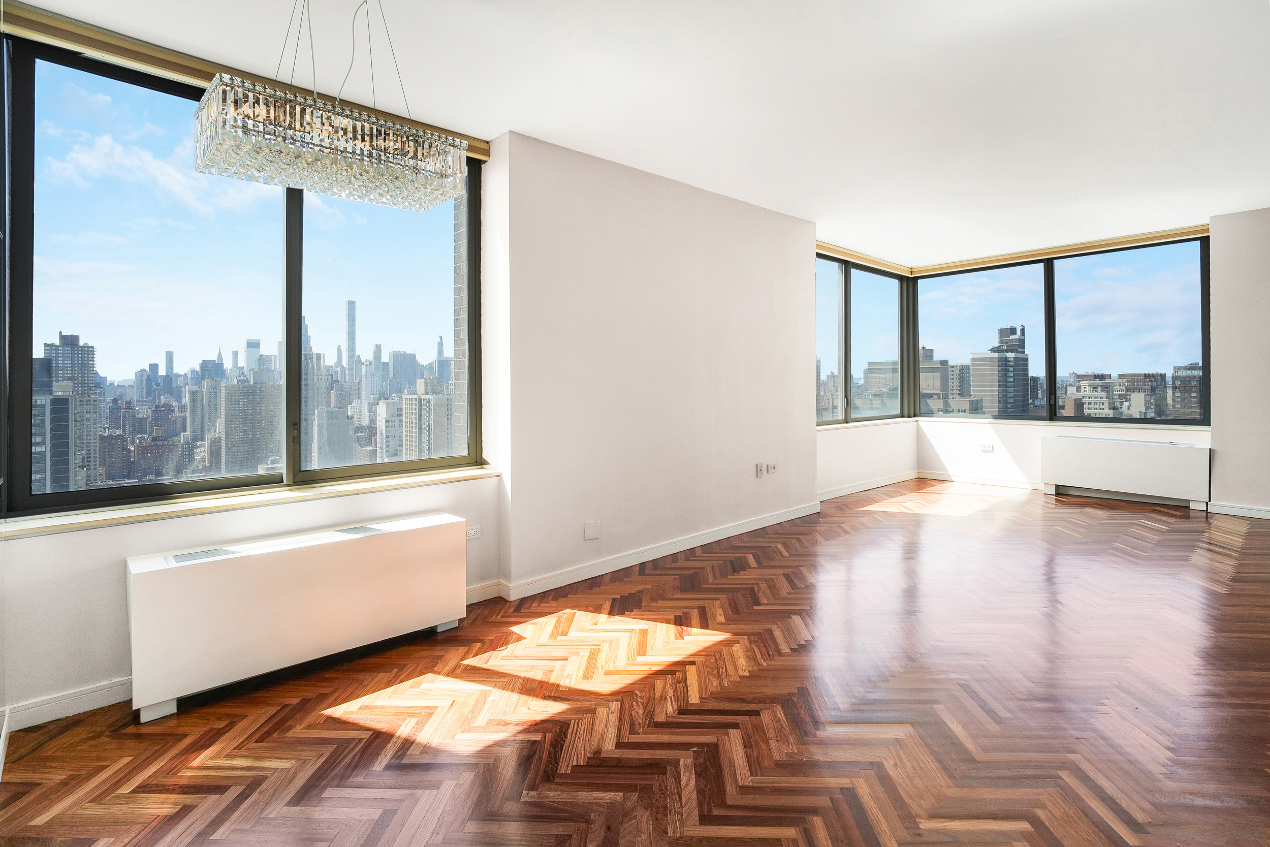 360 East 88th Street, Unit 34A Manhattan, NY 10128 - Photo 2 of 35 a view of an empty room with wooden floor and a window