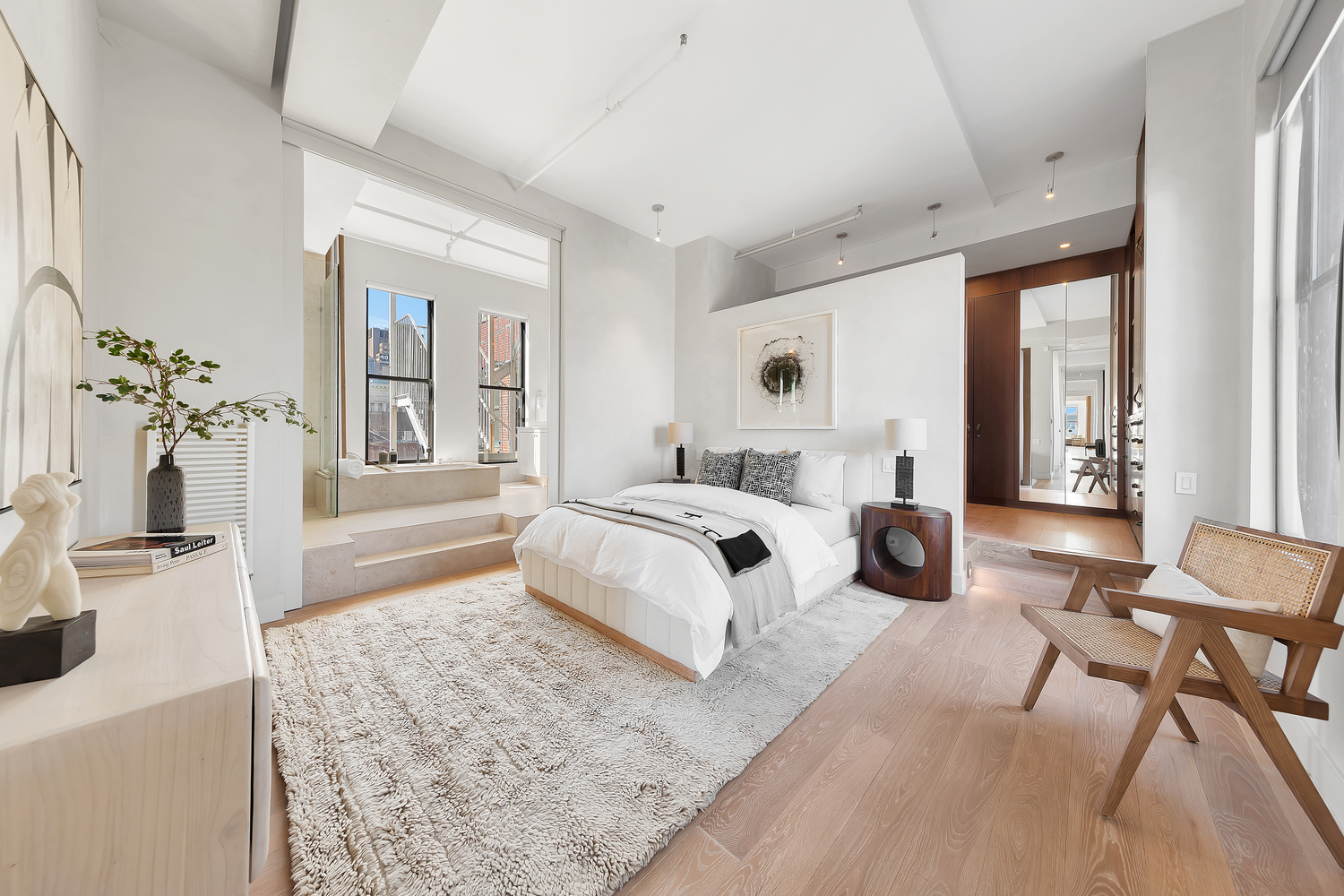 38 Crosby Street, Unit 8 Manhattan, NY 10013 - Photo 9 of 27 a spacious bedroom with a bed and a chandelier