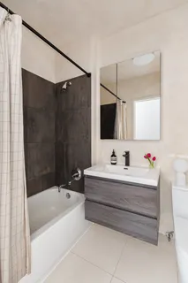 a bathroom with a bathtub a mirror a sink and vanity