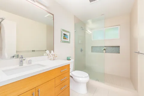 a bathroom with a sink a toilet and shower