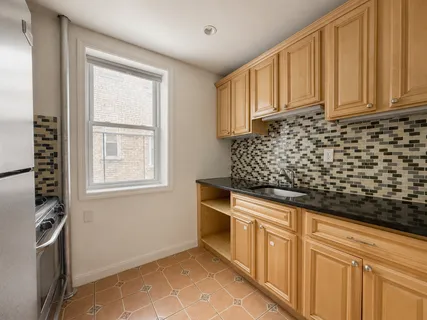 a kitchen with granite countertop white cabinets and stainless steel appliances