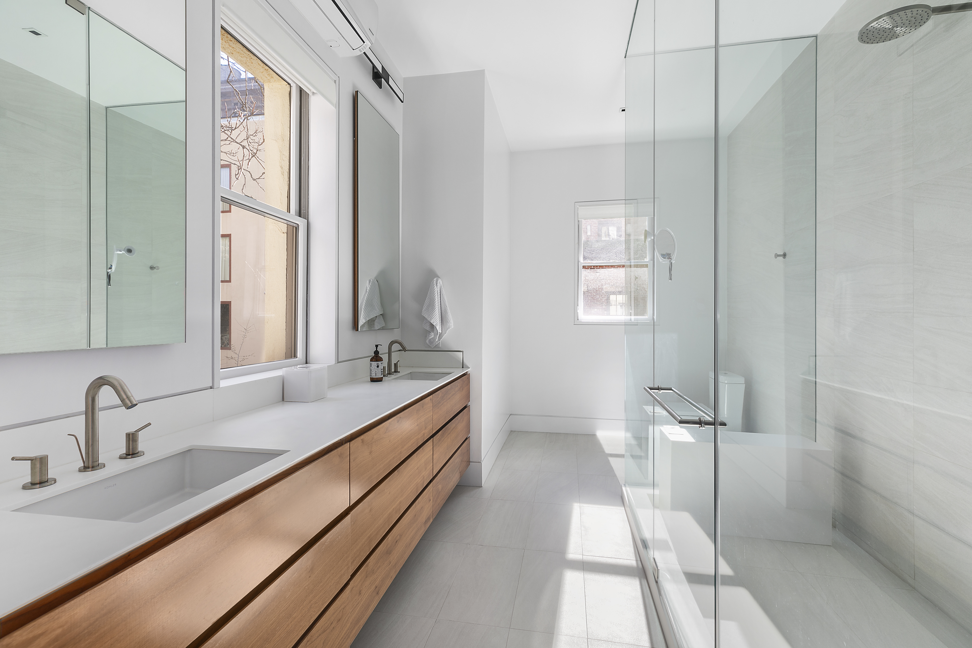 36 East 64th Street Manhattan, NY 10065 - Photo 19 of 27 a bathroom with a double vanity sink and mirror