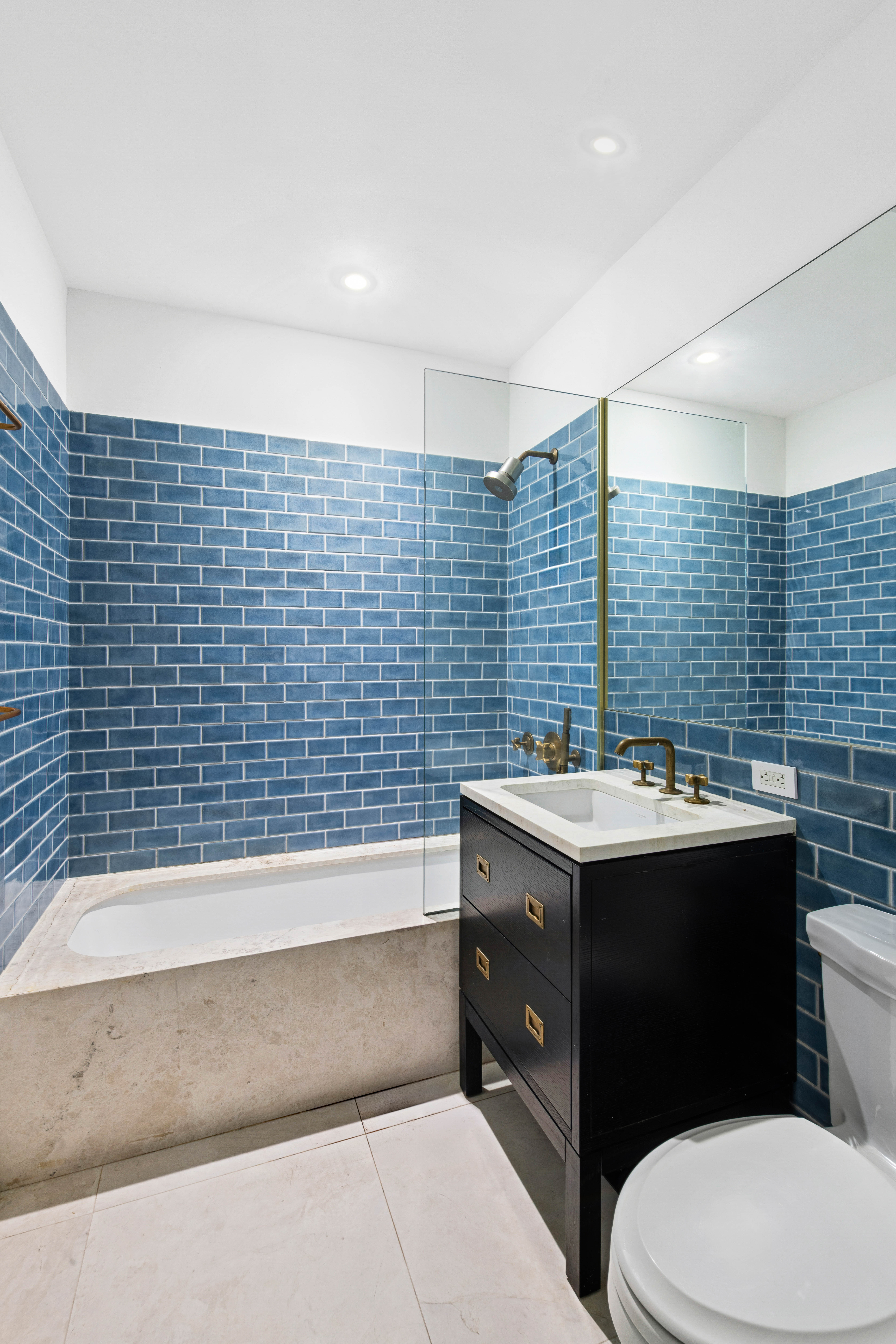 93 Worth Street, Unit 406 Manhattan, NY 10013 - Photo 5 of 11 a bathroom with a sink a toilet and mirror