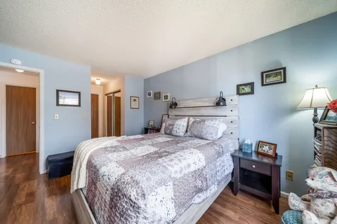 a bedroom with a bed and a wooden floor