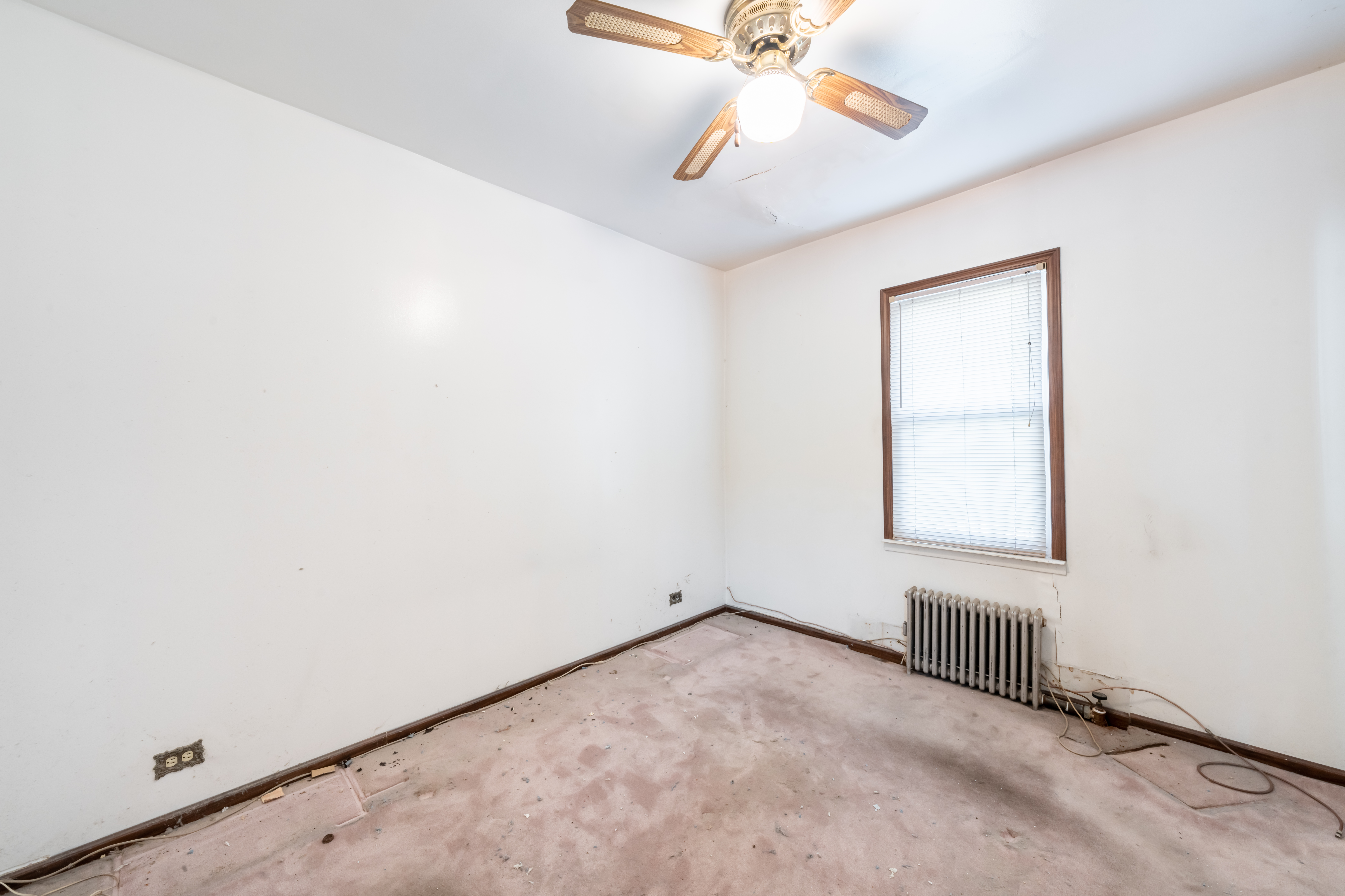 1085 Arnow Avenue Bronx, NY 10469 - Photo 9 of 16 an empty room with a window and a fan
