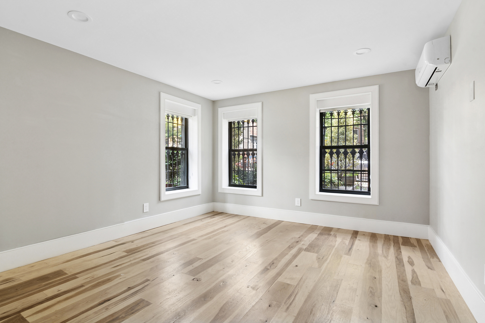 264 Stuyvesant Avenue, Unit 1 Brooklyn, NY 11221 - Photo 5 of 9 a view of an empty room with wooden floor and a window