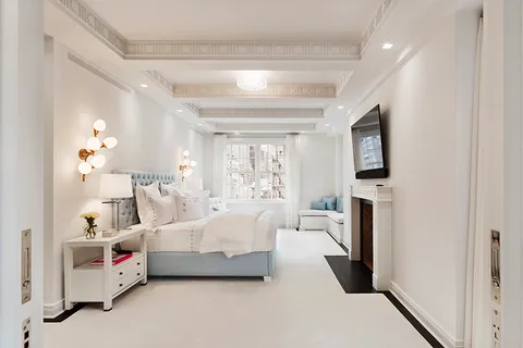 a spacious bedroom with a bed couch and a window