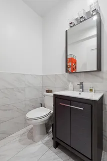 a bathroom with a toilet sink and mirror