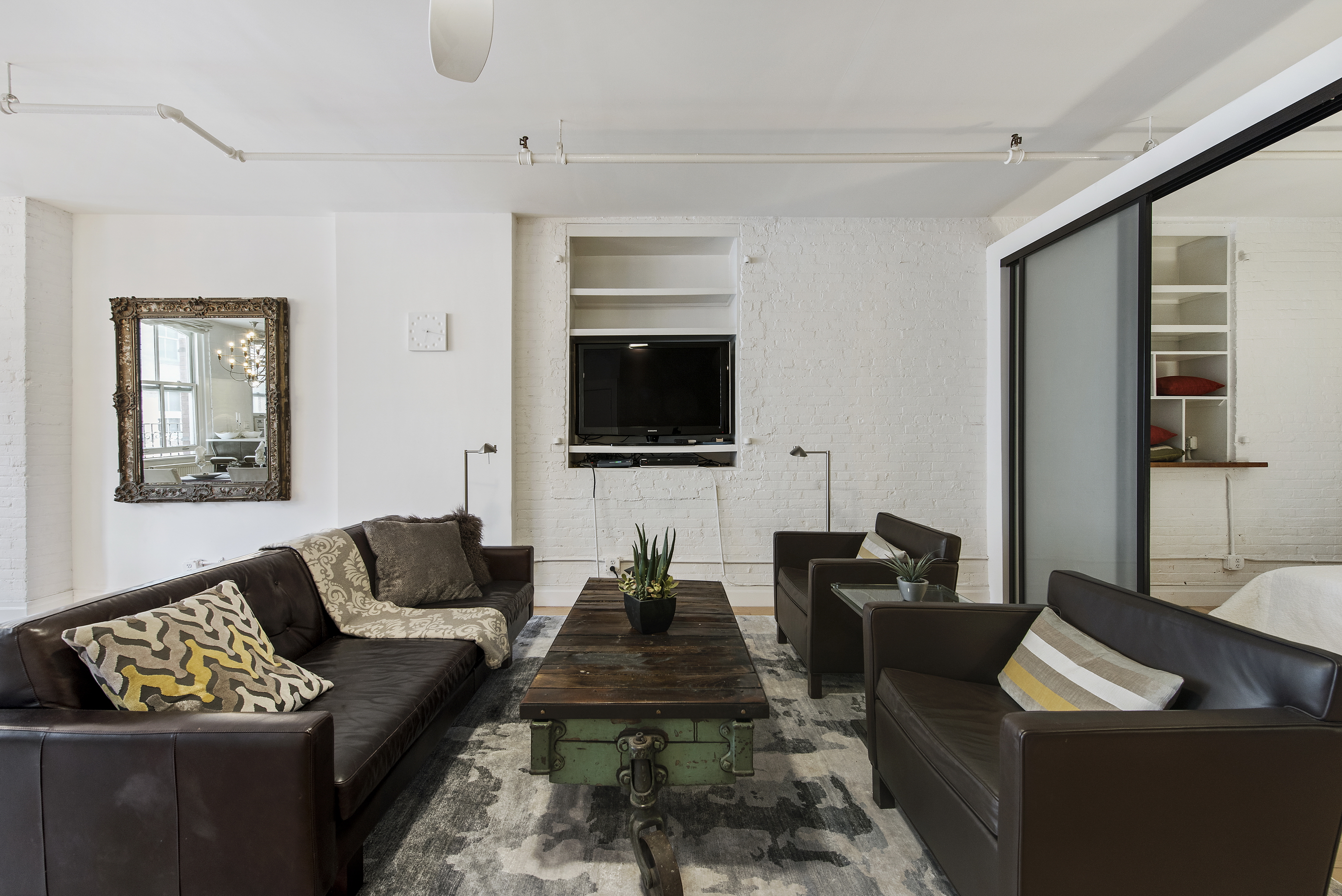 108 Wooster Street, Unit 5B Manhattan, NY 10012 - Photo 2 of 9 a living room with furniture and a flat screen tv