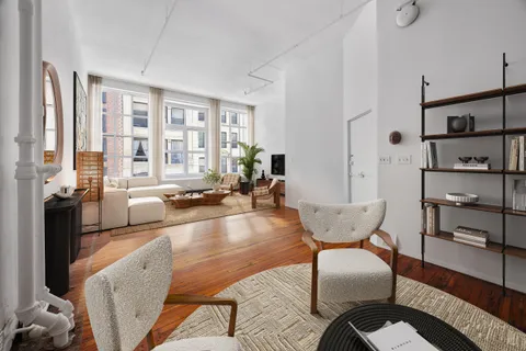 a living room with furniture wooden floor and a large window
