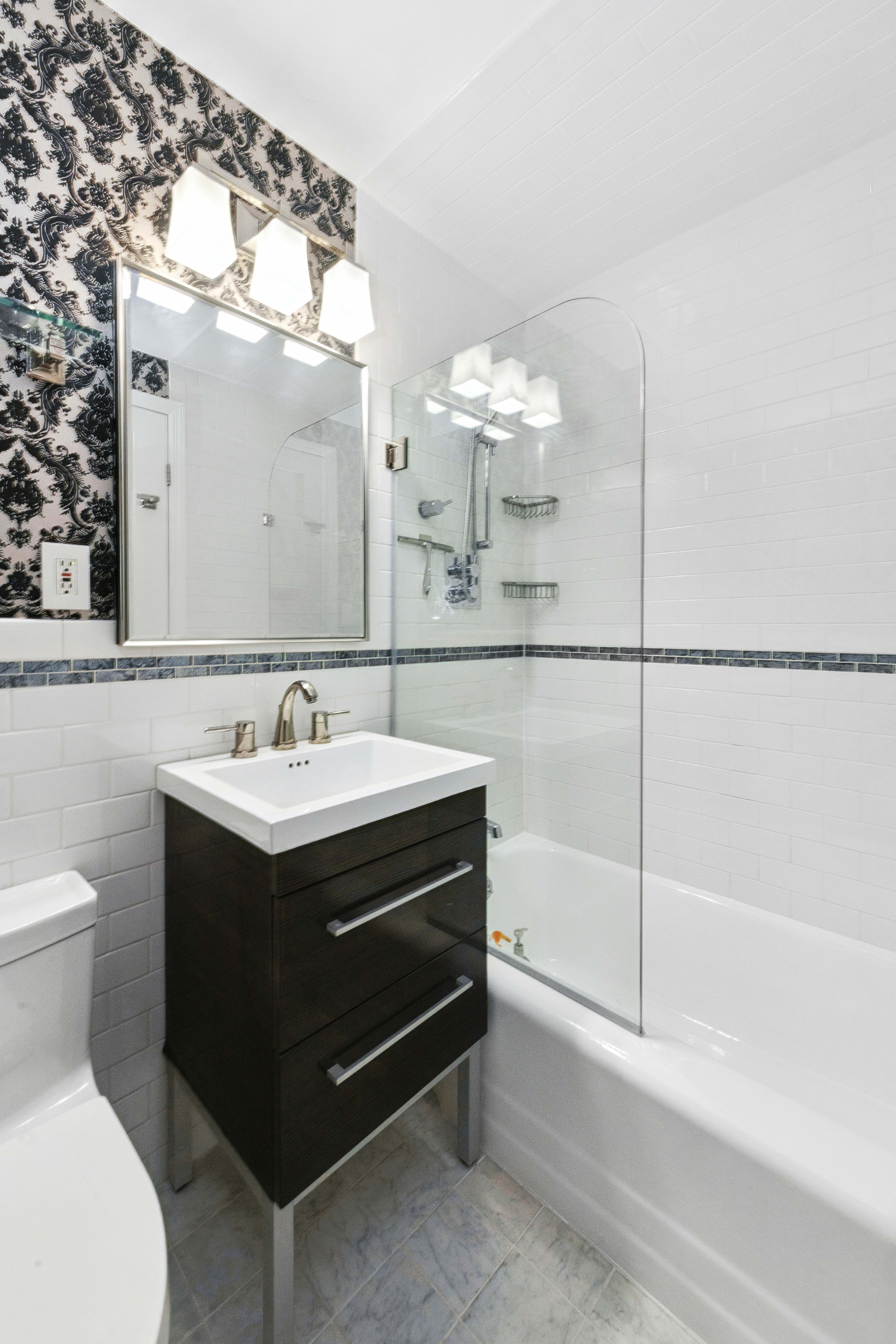 305 East 40th Street, Unit 19CD Manhattan, NY 10016 - Photo 12 of 16 a bathroom with a sink mirror and a shower