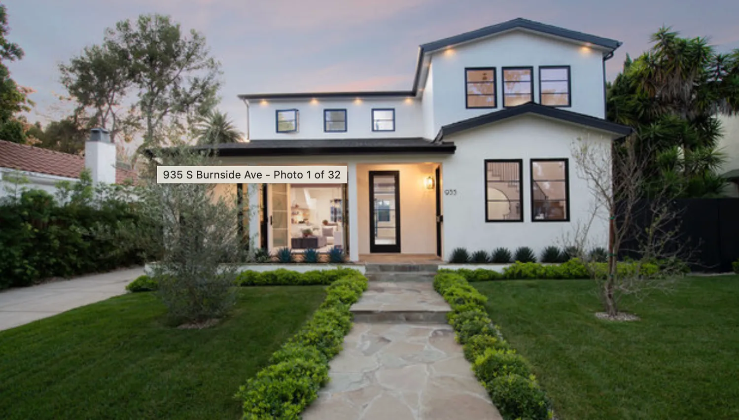 a front view of a house with a yard and trees