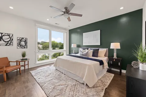 a spacious bedroom with a large bed and a chandelier