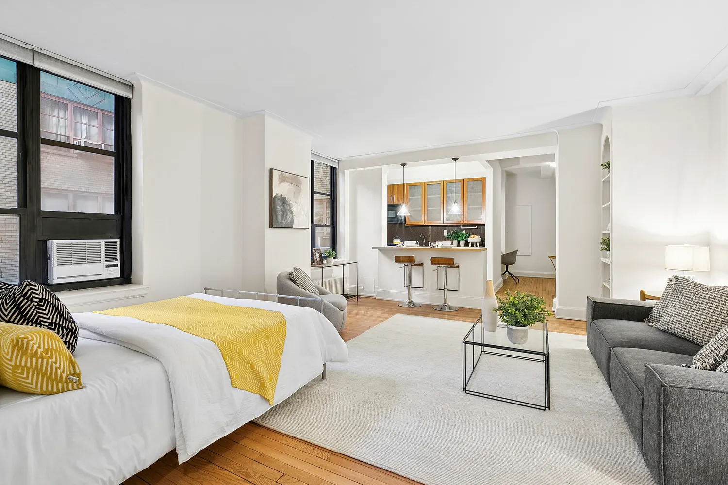 a spacious bedroom with a bed a couch and a flat tv screen next to a window
