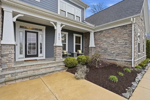 front view of a brick house with potted plants