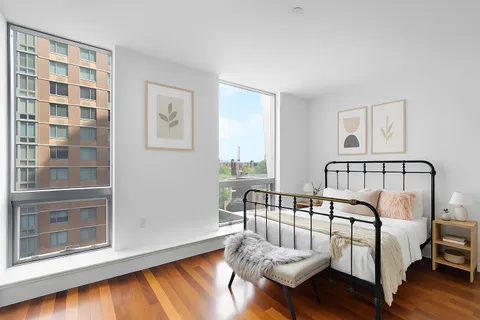 a view of a bedroom with furniture and wooden floor
