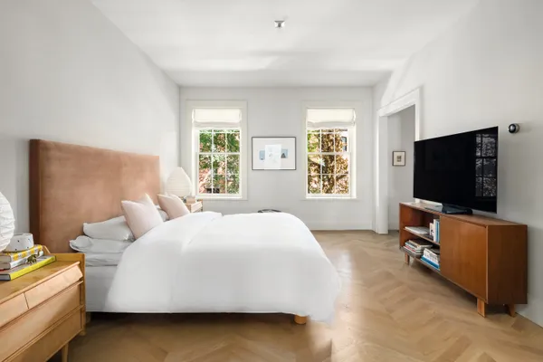 a spacious bedroom with a bed and a window