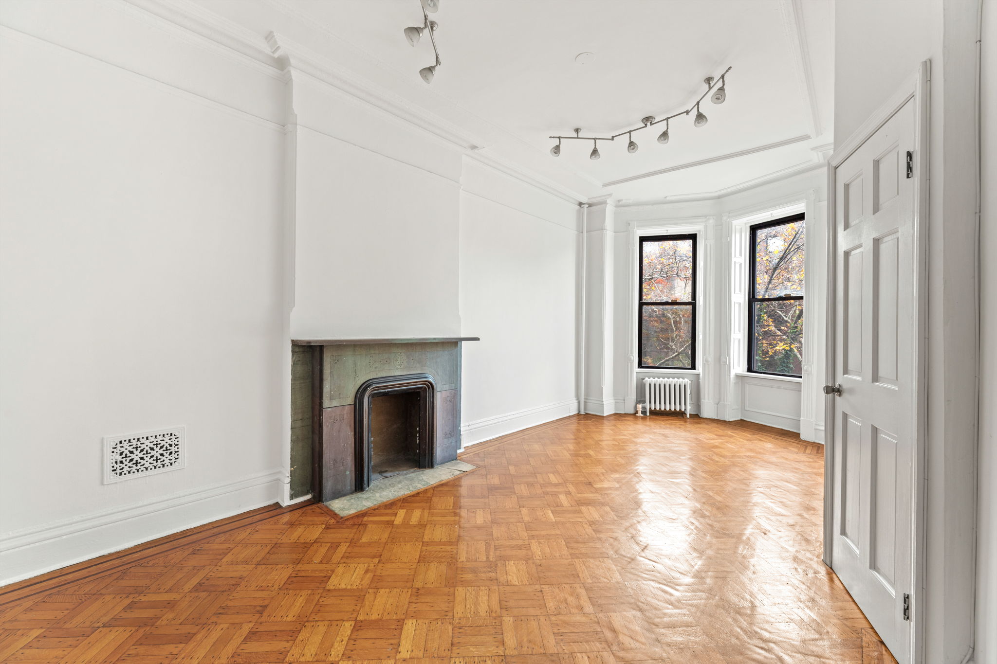 149 Sterling Place, Unit 3 Brooklyn, NY 11217 - Photo 2 of 9 a view of an empty room with a fireplace and a window