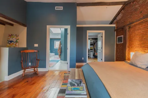 a bedroom with a bed and a table with wooden floor