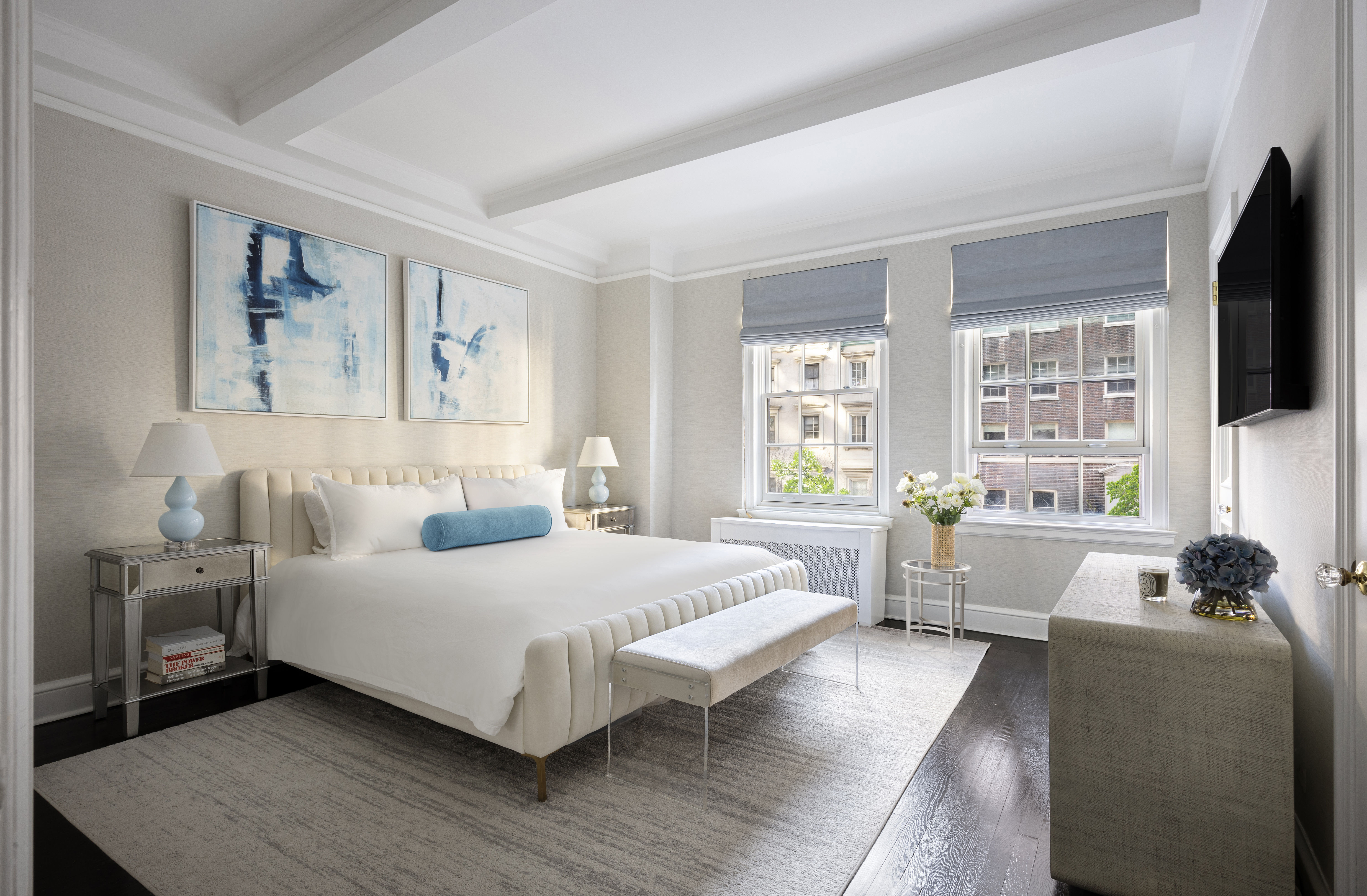 164 East 72nd Street, Unit 3B Manhattan, NY 10021 - Photo 5 of 11 a bedroom with a large bed a flat screen tv and a large window