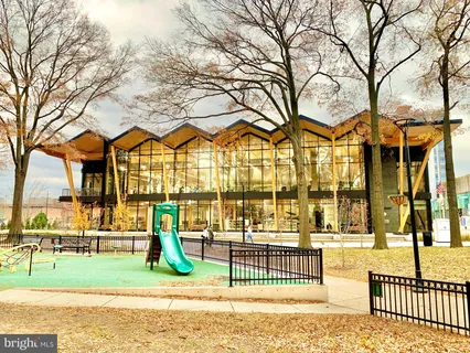 an aerial view of multi story residential apartment building with yard and outdoor seating