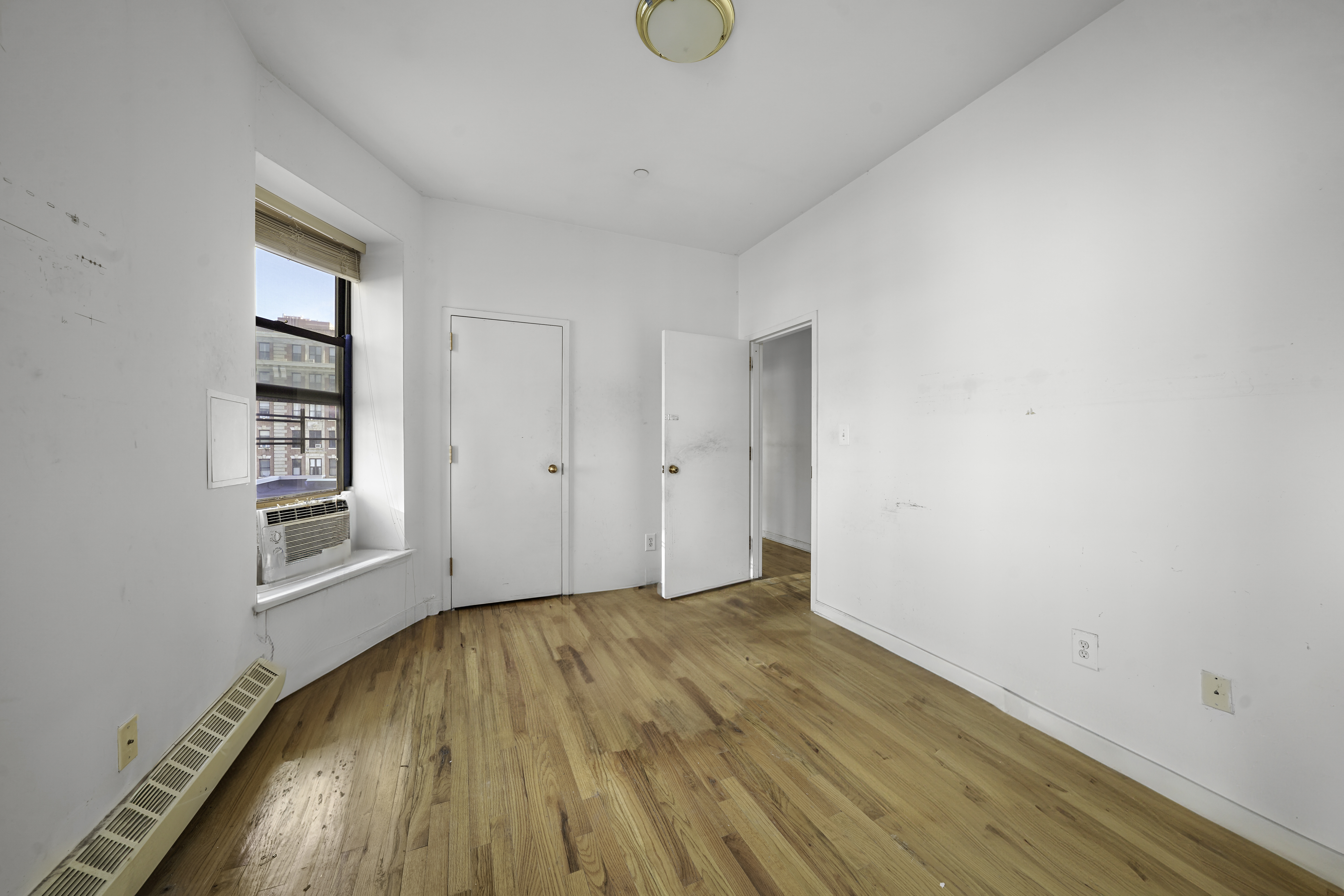 163 Lenox Avenue, Unit 5A Manhattan, NY 10026 - Photo 10 of 16 a view of empty room with wooden floor and fan
