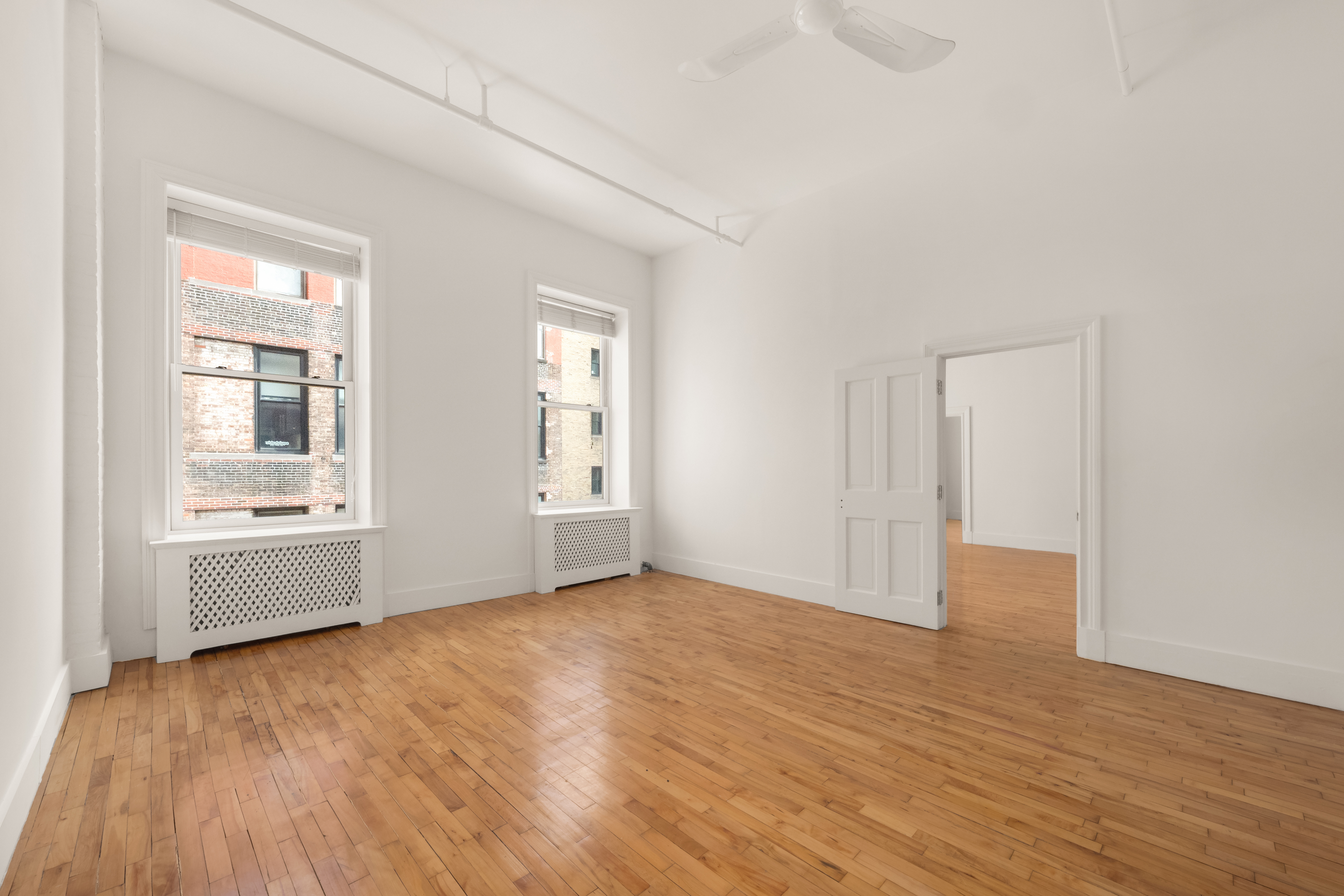 519 Broadway, Unit PHC Manhattan, NY 10012 - Photo 6 of 16 an empty room with wooden floor and windows