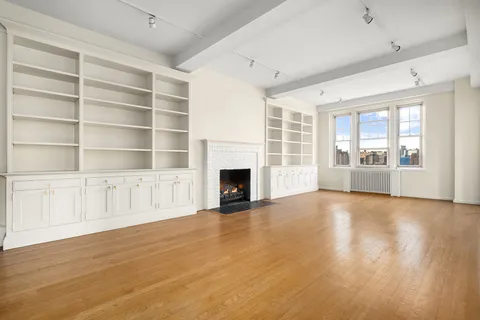 a view of an empty room with a fireplace and a window