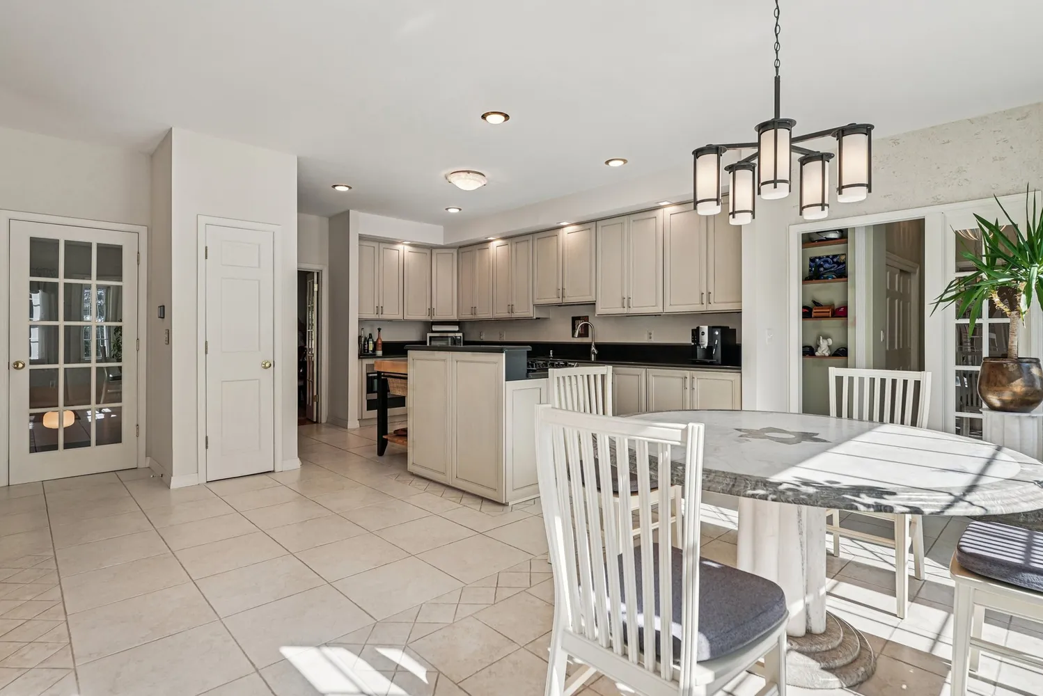 a kitchen with stainless steel appliances kitchen island granite countertop a dining table chairs and granite counter tops