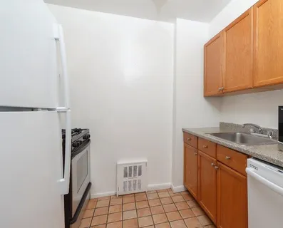 a kitchen with granite countertop a refrigerator and a sink