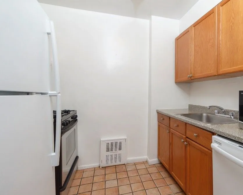 a kitchen with granite countertop a refrigerator and a sink