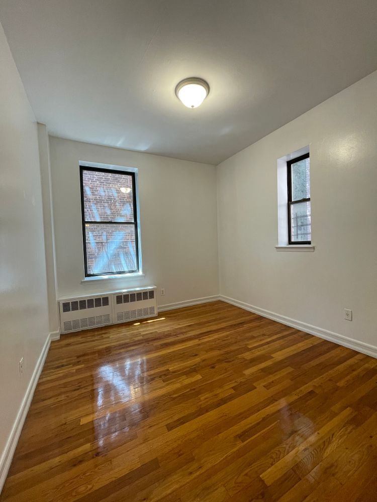 1280 Dean Street, Unit 3E Brooklyn, NY 11216 - Photo 4 of 5 a view of empty room with wooden floor and fan