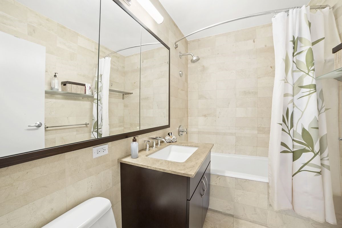 40 West 116th Street, Unit A917 Manhattan, NY 10026 - Photo 5 of 12 a bathroom with a sink and a mirror