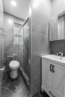 a bathroom with a toilet sink and shower