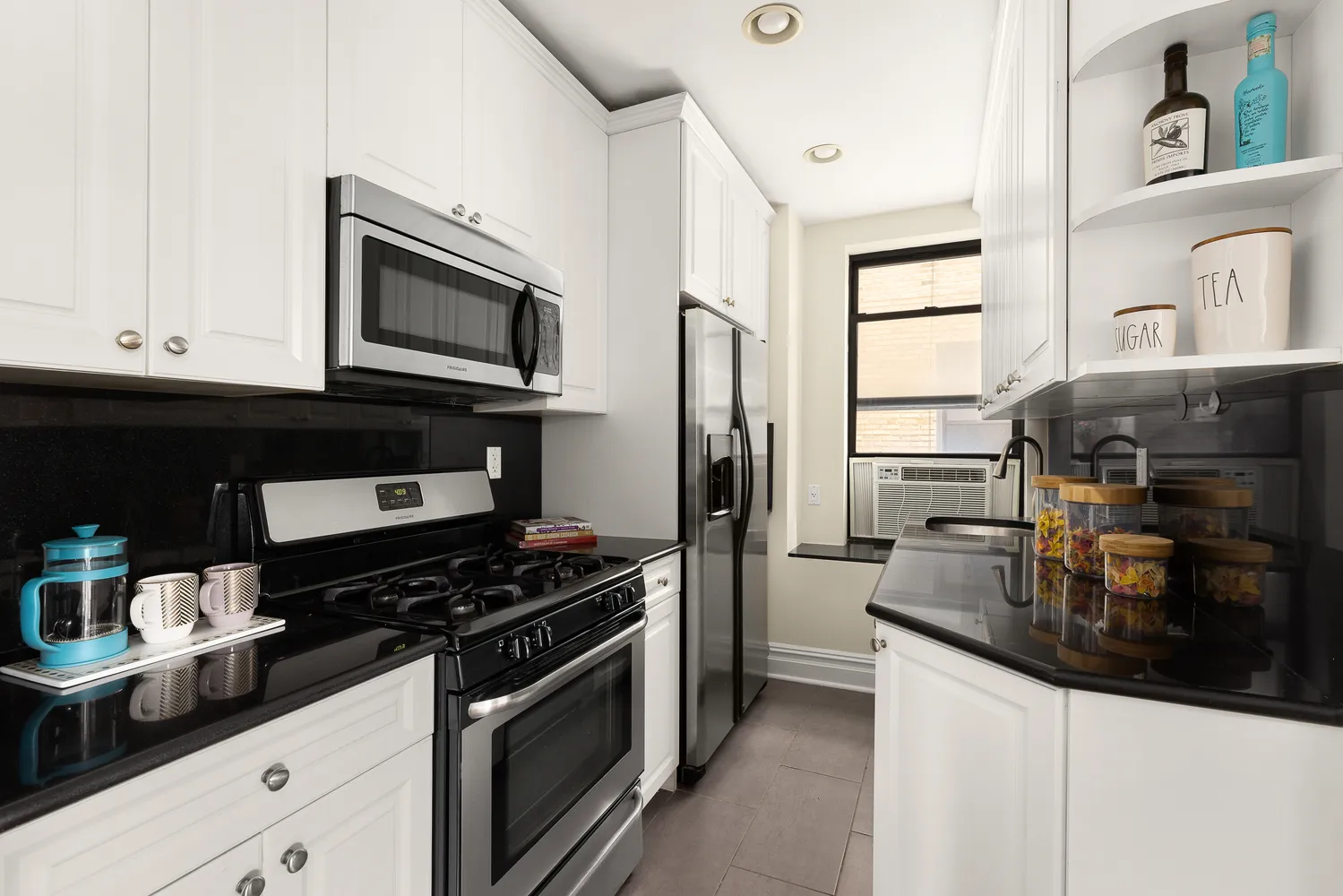 a kitchen with stainless steel appliances a stove a microwave and cabinets