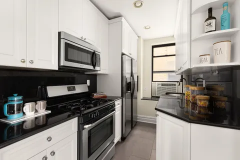 a kitchen with stainless steel appliances a stove a microwave and cabinets