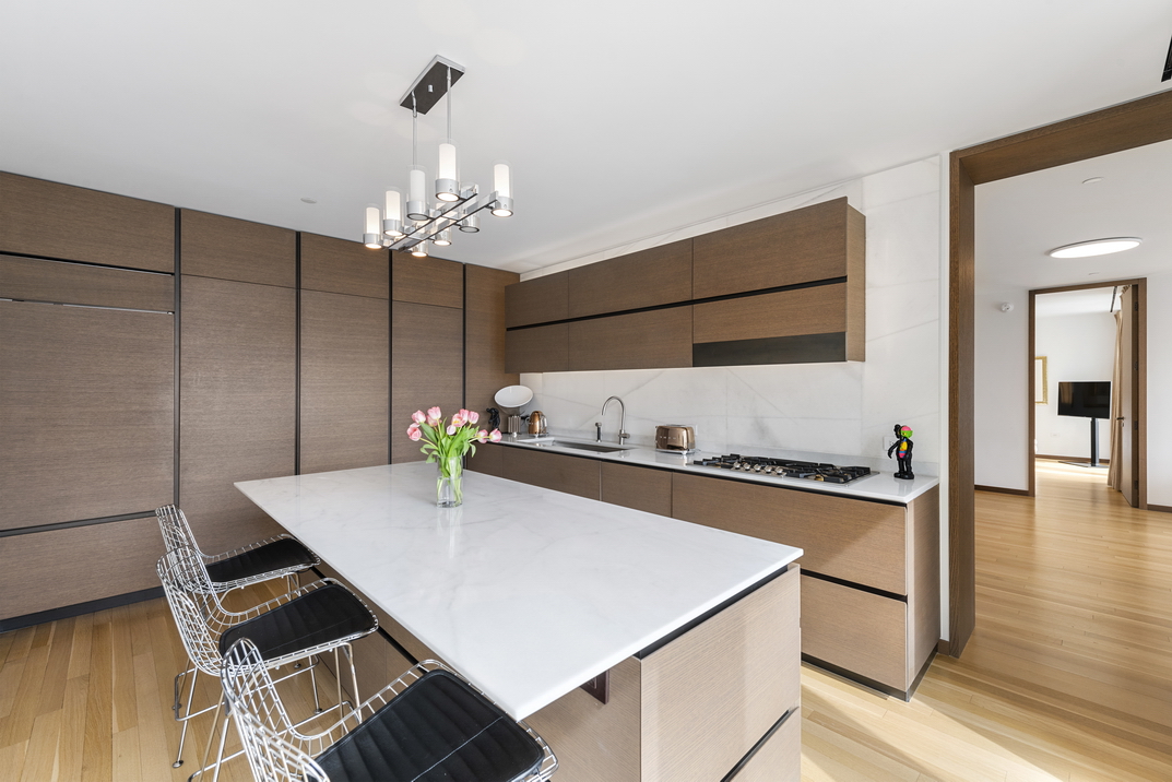 551 West 21st Street, Unit 4D Manhattan, NY 10011 - Photo 5 of 16 a kitchen with stainless steel appliances a stove a refrigerator and chandelier