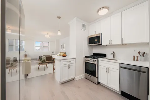 a kitchen with white cabinets and black appliances