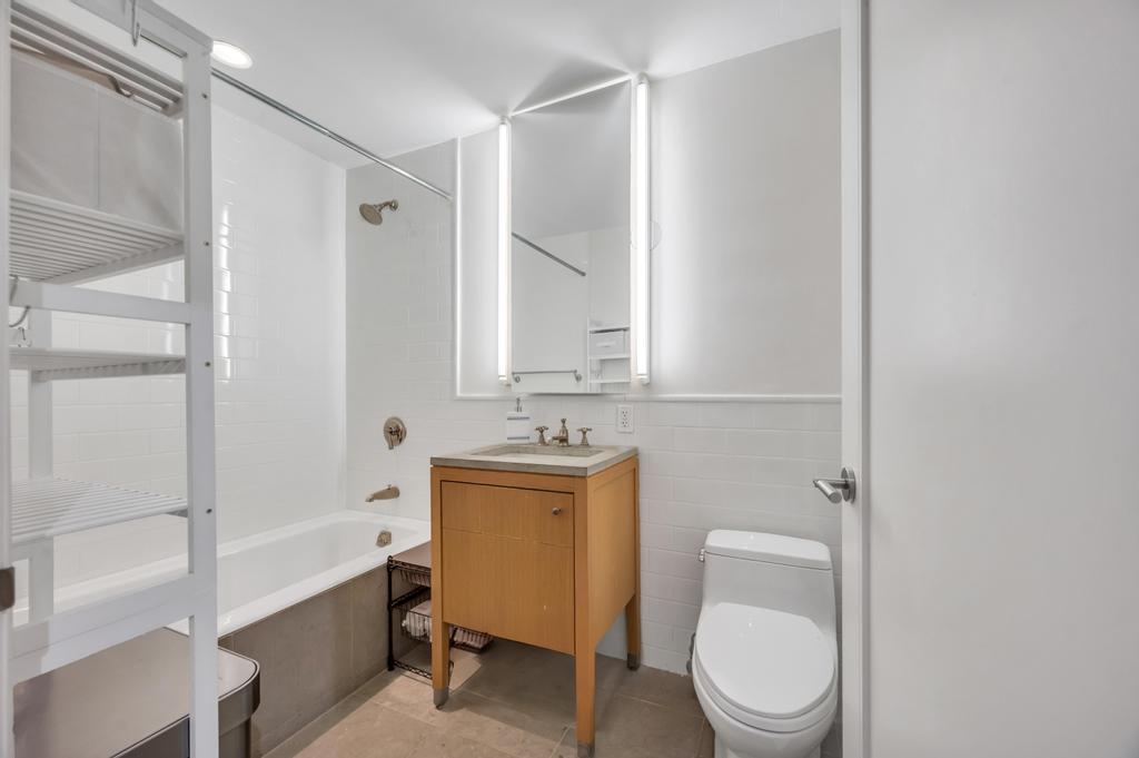 2628 Broadway, Unit 15B Manhattan, NY 10025 - Photo 15 of 22 a bathroom with a granite countertop toilet sink and mirror