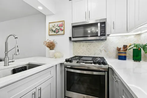 a kitchen with microwave cabinets and a stove top oven