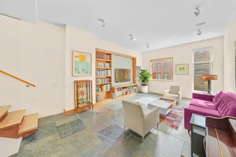 a living room with furniture a flat screen tv and a large window