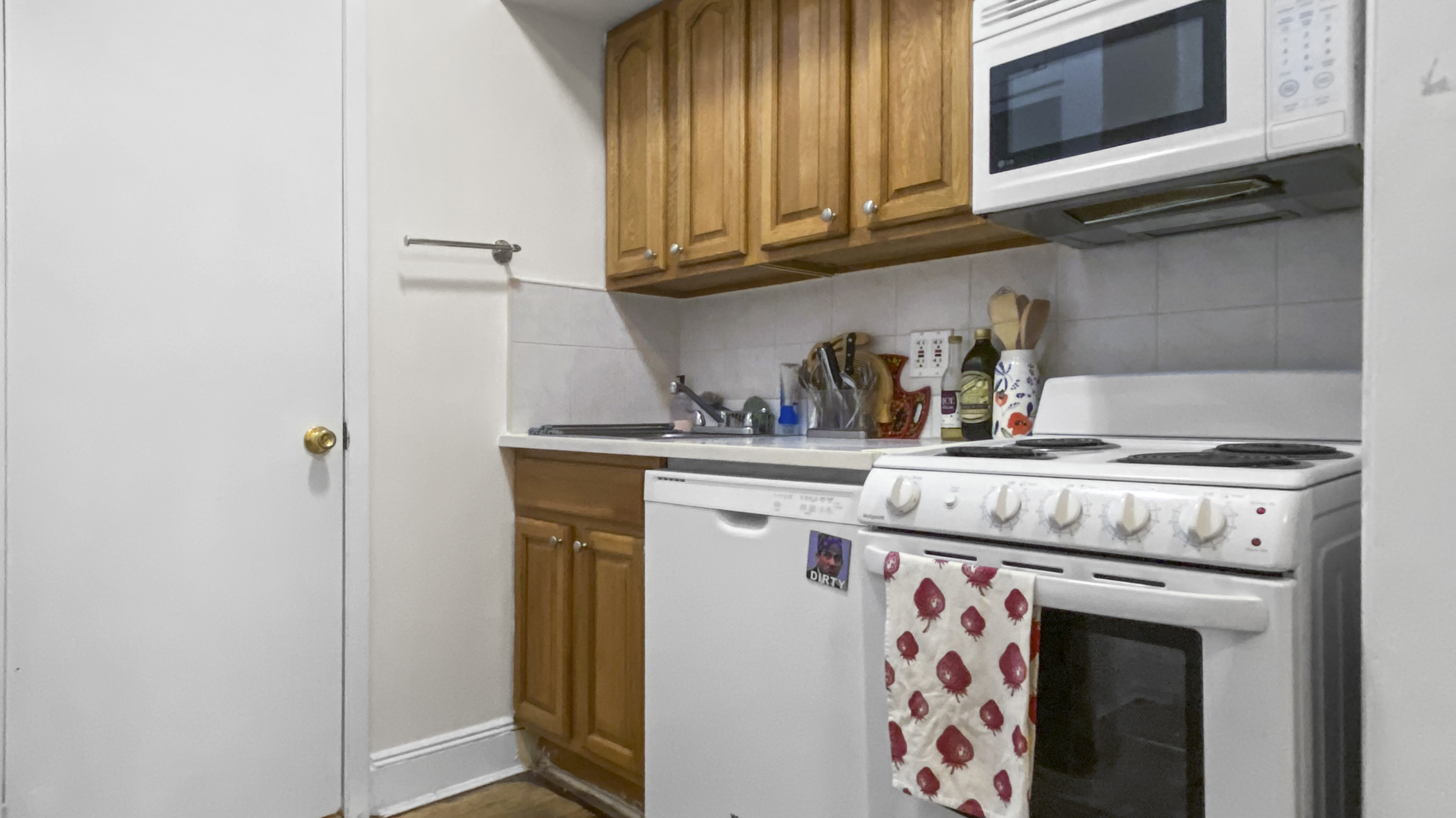 1059 2nd Avenue, Unit 3AB Manhattan, NY 10022 - Photo 5 of 8 a kitchen with stainless steel appliances granite countertop a sink stove and cabinets