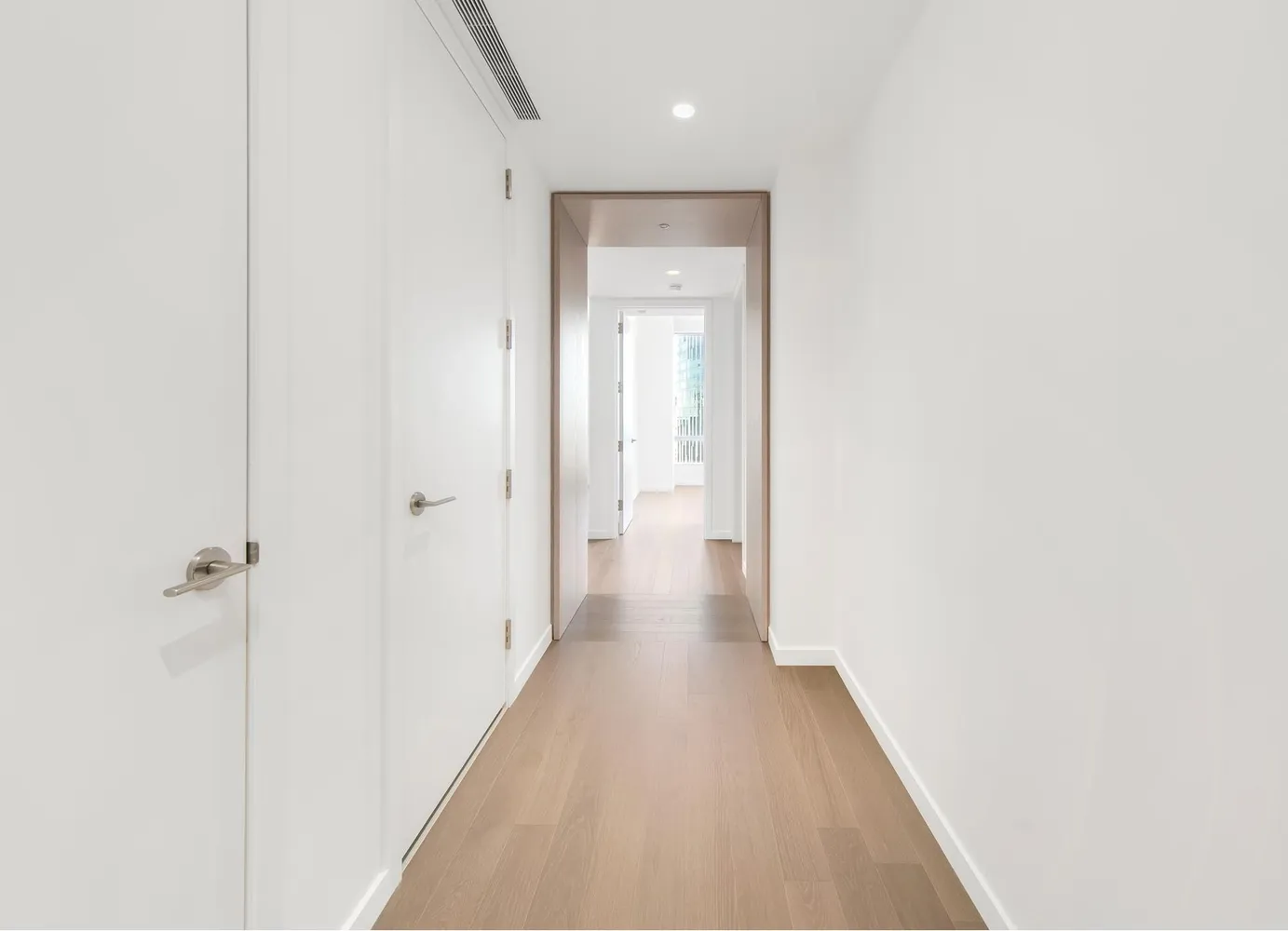 a view of a hallway with wooden floor