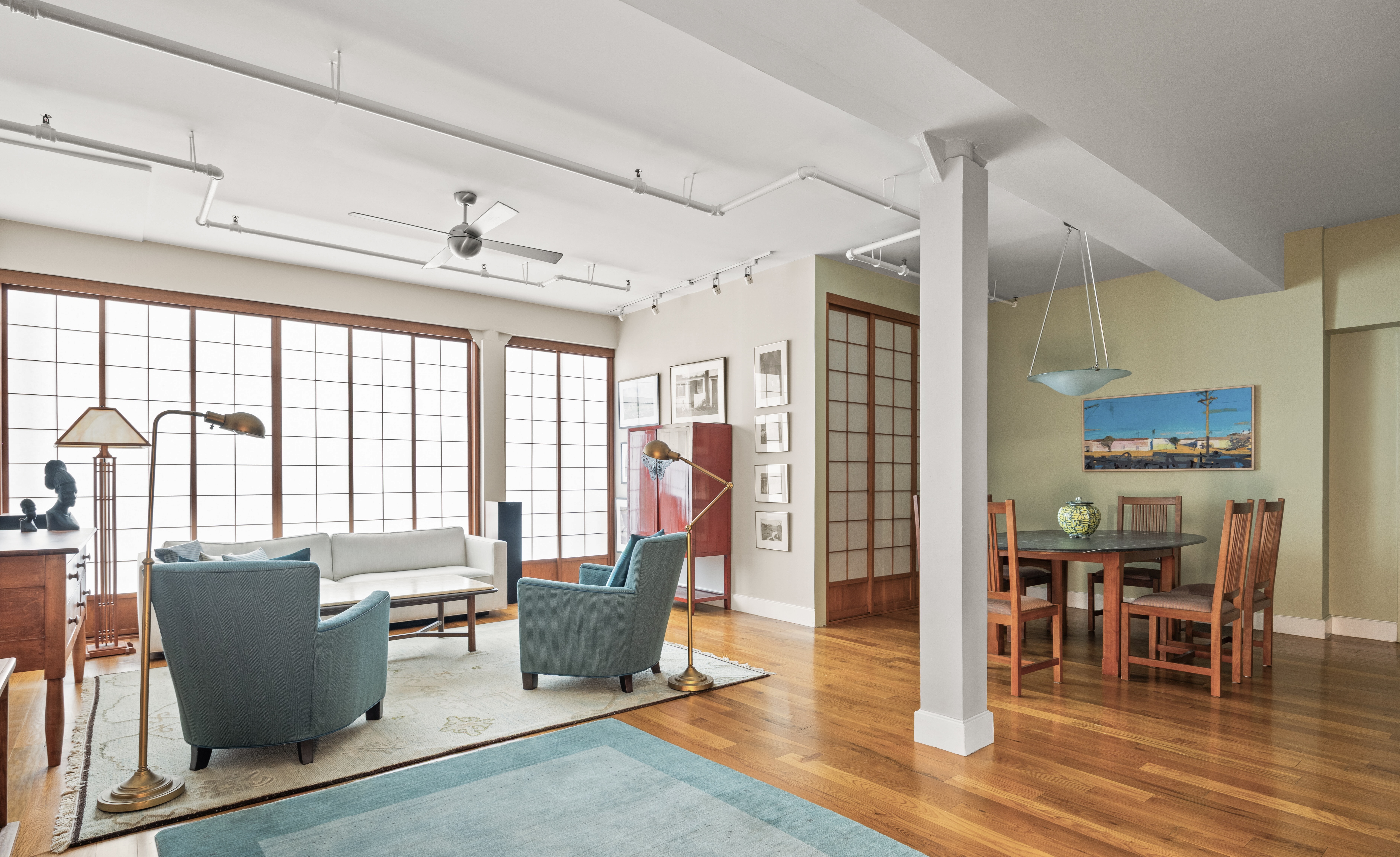 a living room filled with furniture and large windows
