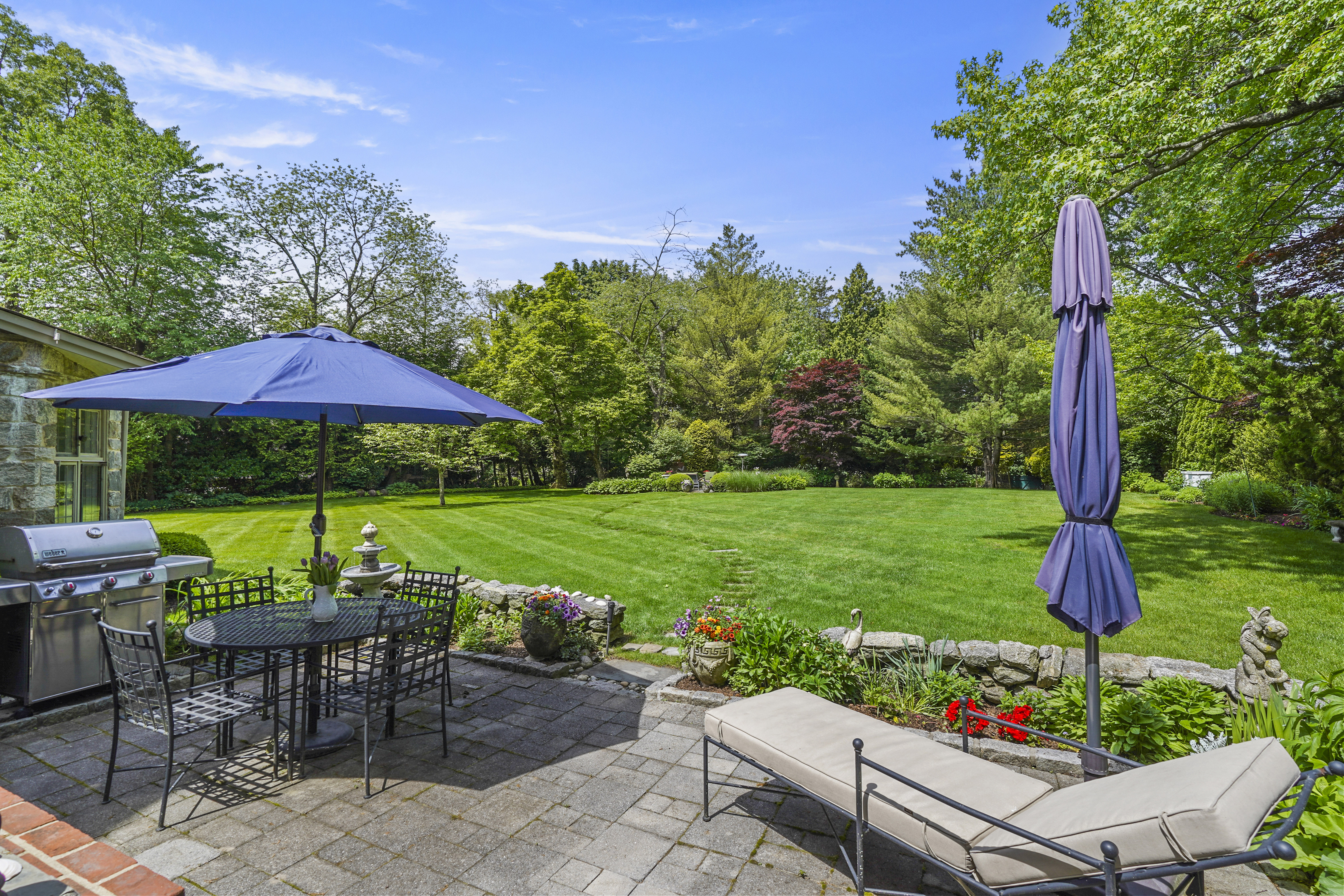19 Avon Road Larchmont, NY 10538 - Photo 25 of 35 a view of a table and chairs under an umbrella in front of house
