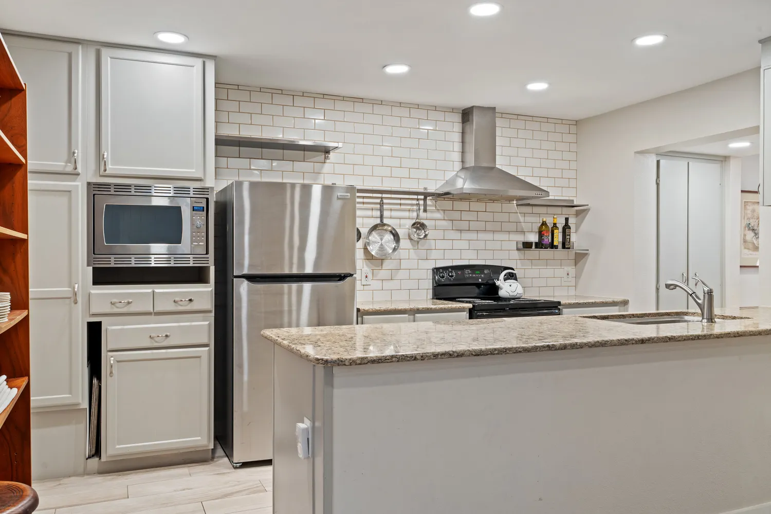 a kitchen with stainless steel appliances granite countertop a sink and a refrigerator