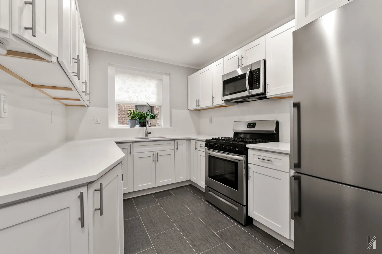 a kitchen with a sink a stove top oven and white stainless steel appliances