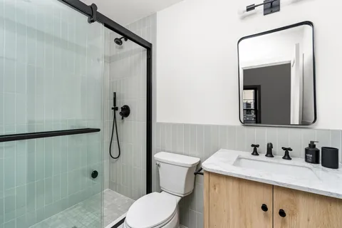 a bathroom with a granite countertop sink toilet and shower