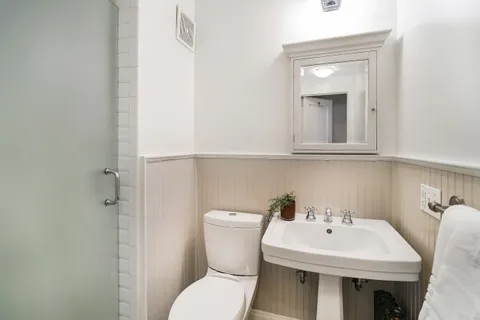 a bathroom with a sink a toilet and a mirror