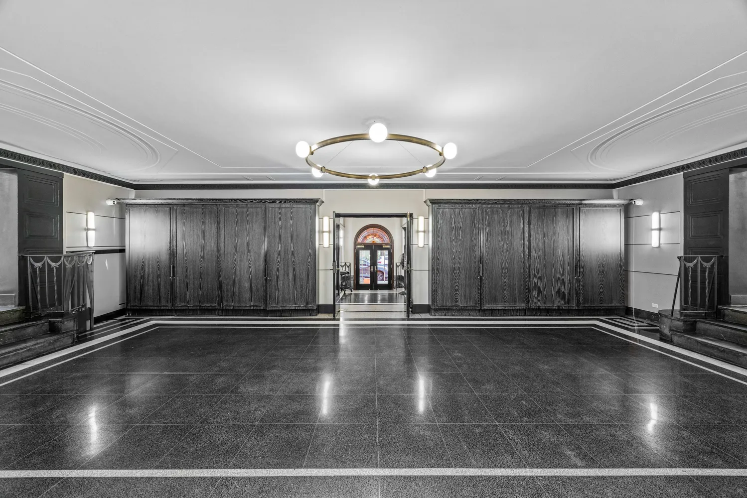 a view of an empty room with stairs wooden floor and a cabinet